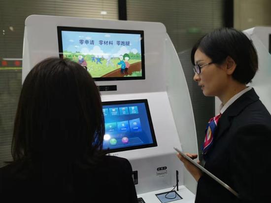 工作人員指導(dǎo)市民使用自助服務(wù)機(jī)。浙江省人社廳供圖